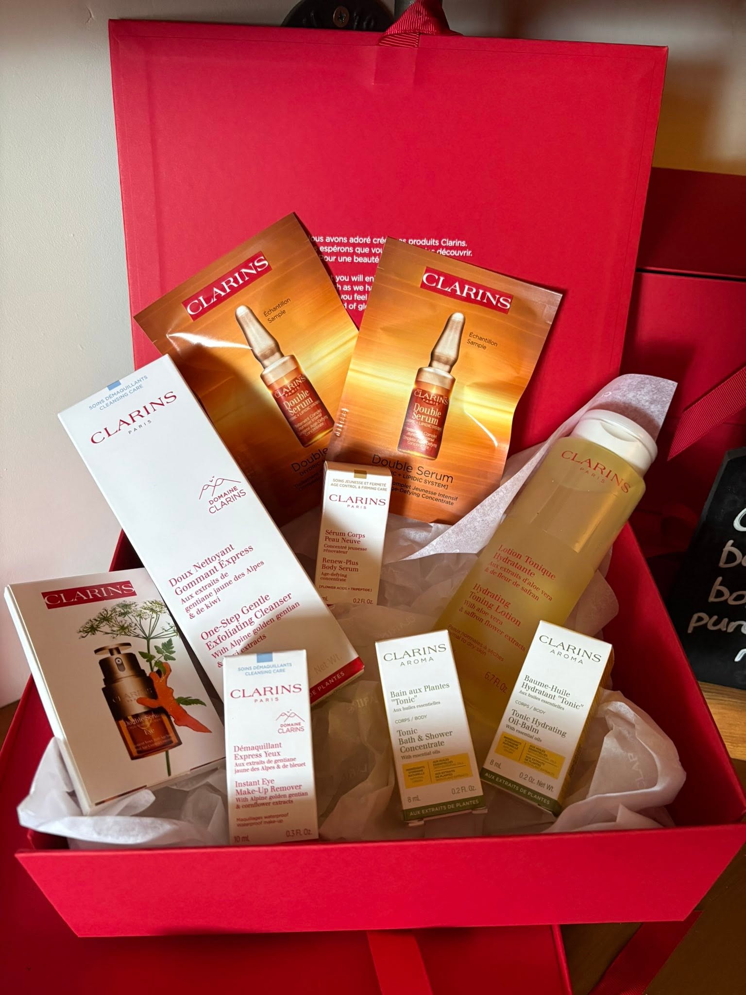 A red box of Clarins skincare products and samples from The Olive Tree