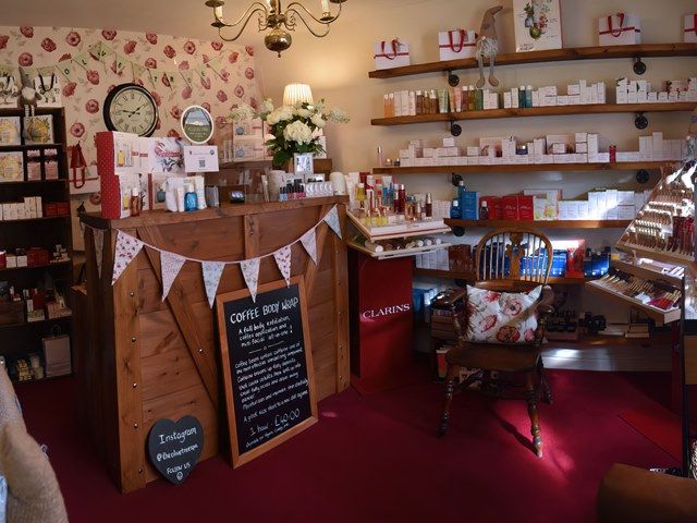 The Olive Tree reception and in-house shop, with bunting, Clarins shelves, poppy wallpaper and the wall clock